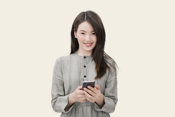 Woman in Gray Button-up Long-sleeved Dress Holding Black Smartphone